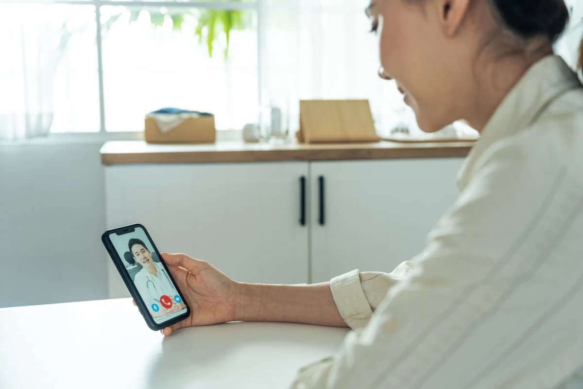 スマホでオンライン診療を受ける女性